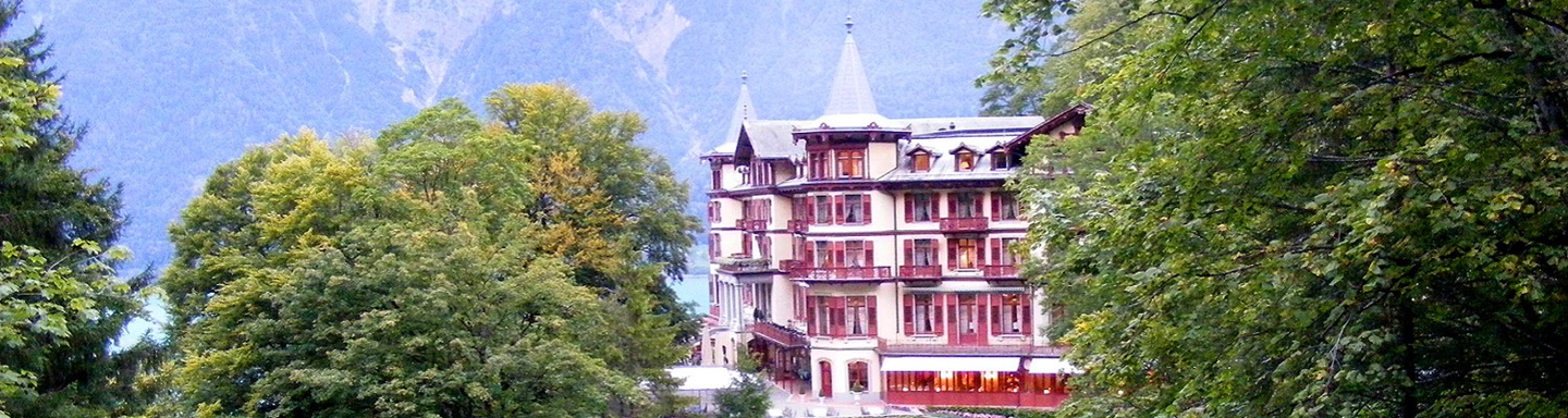 Blick auf das von Bäumen umrahmte Hotel oberhalb der Giessbachfälle bei Iseltwald.