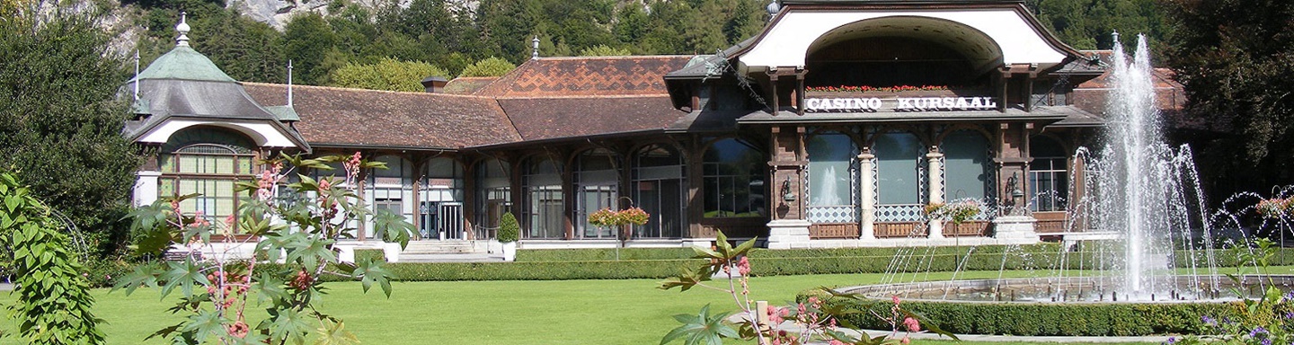 Blick auf das Casino von Interlaken mit seinem prächtigen, von bunten Blumen und herrlichen Wasserspielen geprägten Garten.