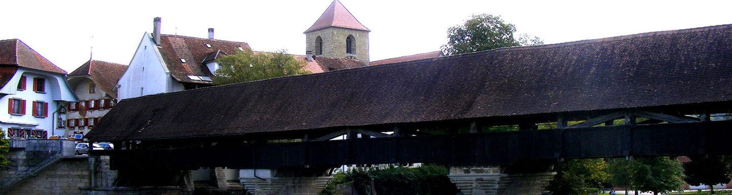 Die aus dem Jahr 1557 stammende, gedeckte Holzbrücke von Aarberg, im Hintergrund der Kirchturm.