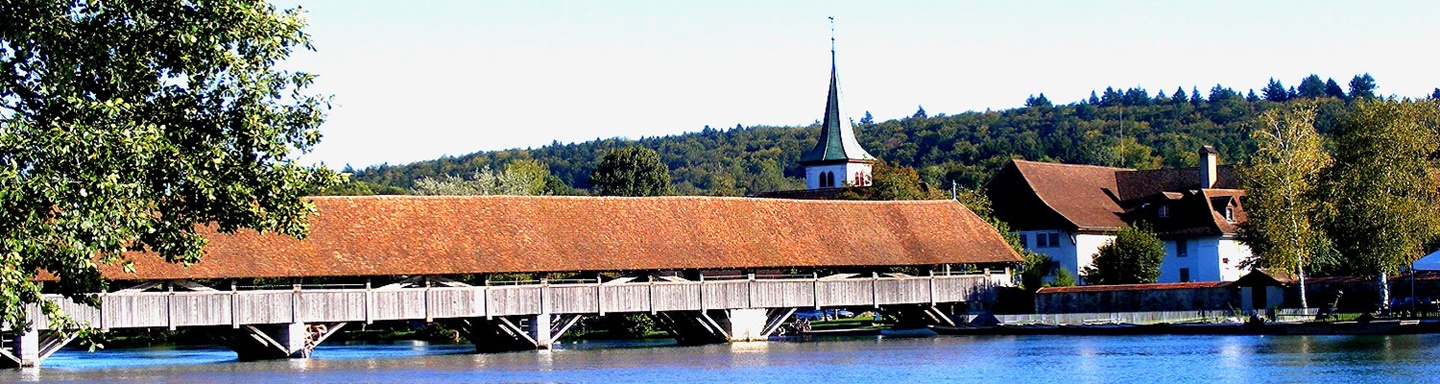 Eine der vielen gedeckten Holzbrücken über die Aare, im Hintergrund der Kirchturm von Wangen.