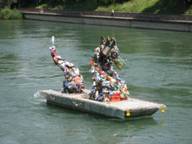 Floß auf der Aare mit aus Müll erbauter Drachenskulptur.