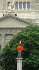 Eine der zahlreichen Brunnenfiguren in Bern, im Hintergrund das Schweizer Bundeshaus.