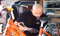 Mitarbeiter repariert orangefarbenes Leihrad