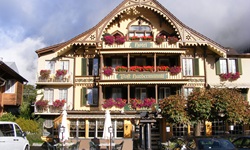 Die imposante, mit herrlichen Holzschnitzereien verzierte Fassade des Hotels "Post Hardermannli" in Interlaken
